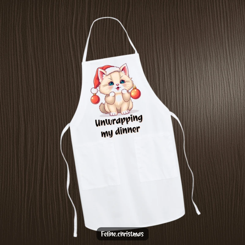 Funny cat apron: a fluffy kitten in a Santa hat playfully bats at a dangling ornament while cooking during the holidays.