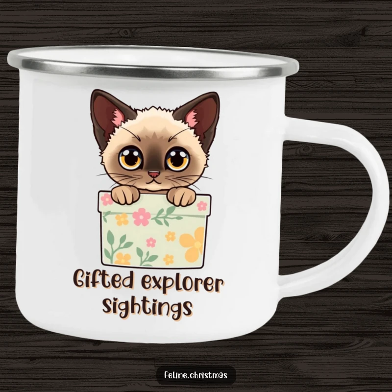 Funny camping mug showing a Siamese cat peeking out of a decorated gift box with wide eyes, perfect for holiday trips.