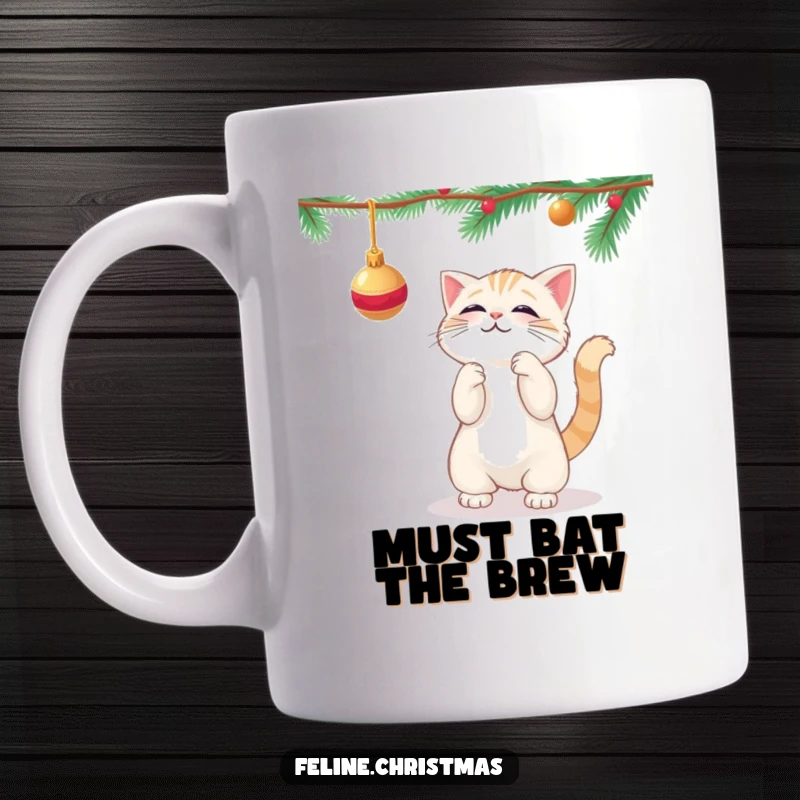 Funny kawaii cat playfully batting at a dangling Christmas ornament on a festive mug.