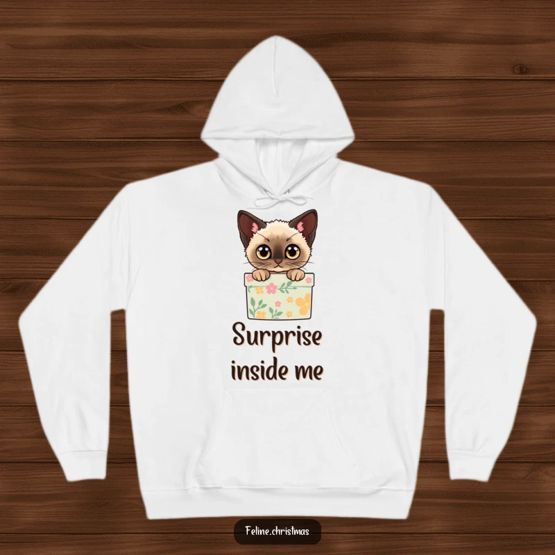 Funny hoodie with a Siamese cat peeking out of a decorated gift box with wide eyes, perfect for cozy holidays.
