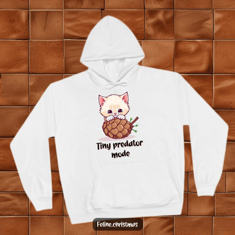Funny fluffy kitten pouncing on a rolling pinecone, a cozy and humorous hoodie for cat lovers.