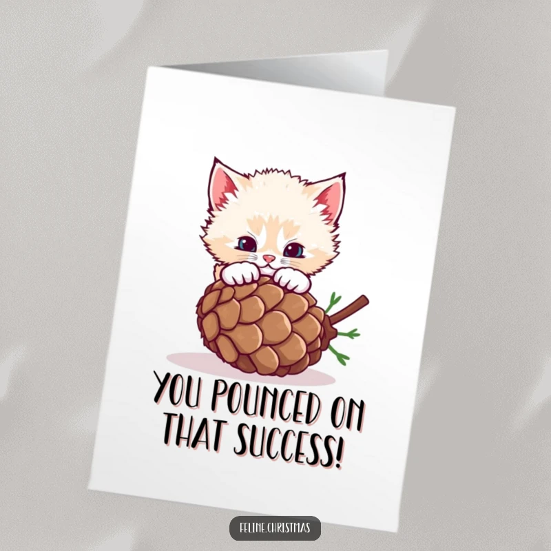 Funny free printable congratulations card featuring a fluffy kitten enthusiastically pouncing on a rolling pinecone.