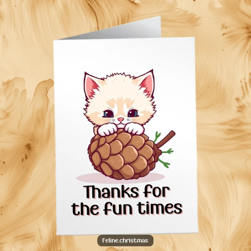 Funny free printable thank you card of a fluffy kitten pouncing on a rolling pinecone with playful intent.