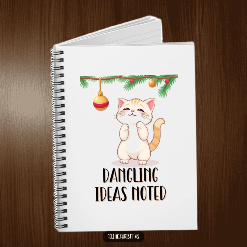Funny kawaii cat playfully batting at a dangling Christmas ornament, on the cover of a cute notebook.