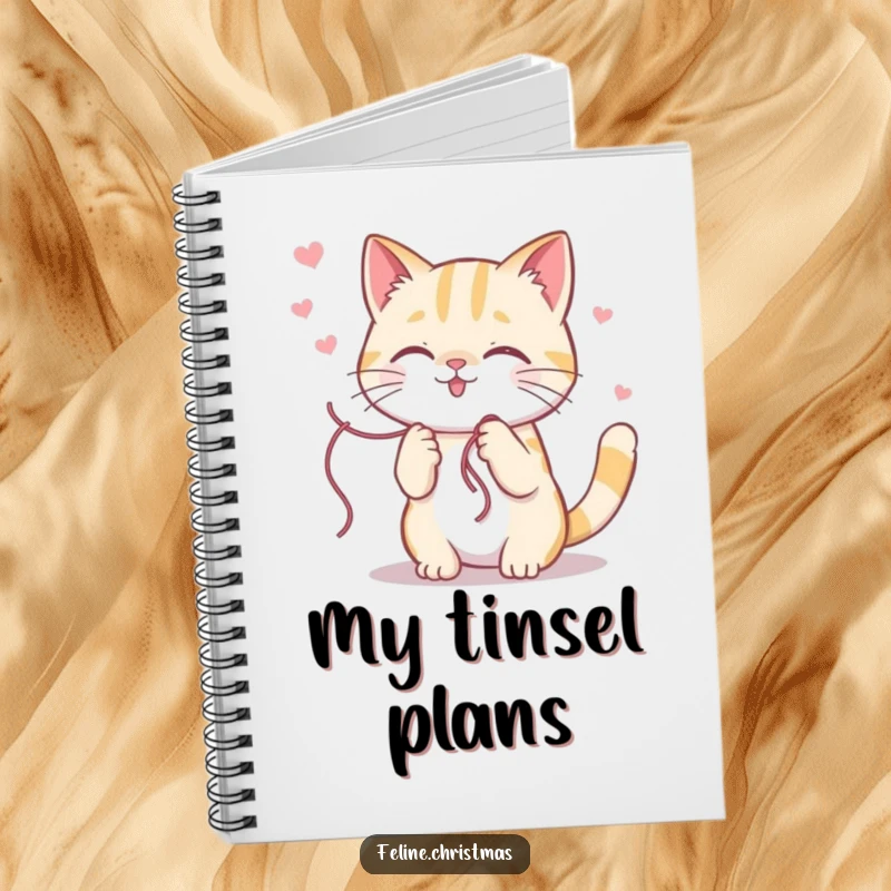 Funny kawaii cat character getting delightfully stuck in a shiny string of holiday tinsel, featured on a lined notebook cover.