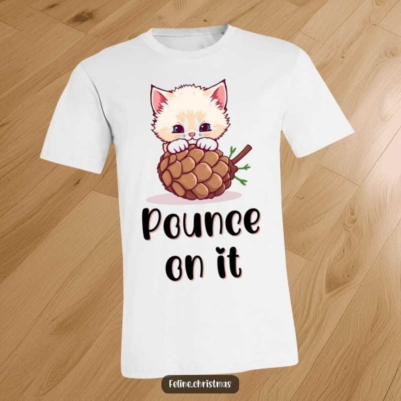 Funny fluffy kitten leaping to pounce on a rolling pinecone, printed on a soft and funny t-shirt.